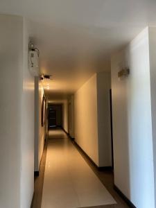 einen Flur mit weißen Wänden und einem langen Flur in der Unterkunft Bangkok Resort and Spa in Ban O Pao