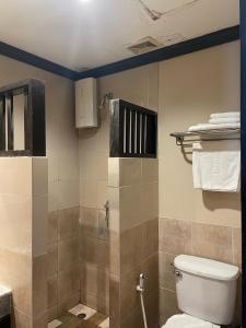 ein Badezimmer mit Toilette und Dusche mit Handtüchern in der Unterkunft Bangkok Resort and Spa in Ban O Pao