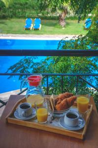 a tray of breakfast food on a table with orange juice at Jasmine Apartments in Sidari