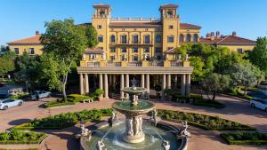 a large yellow building with a fountain in front of it at Palazzo Hotel in Johannesburg