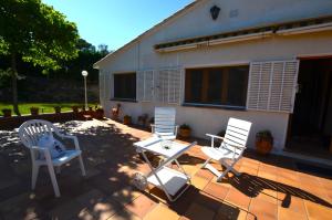 three chairs and a table on a patio at Can Torrent 10 Km Lloret De Mar in Vidreres