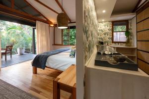 圣卢西亚马卡卡塔纳湾山林小屋的房屋内一间卧室,配有一张床和一间厨房