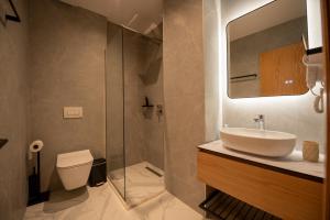 a bathroom with a sink and a shower and a toilet at Calma Boutique Hotel in Vlorë +19 photos