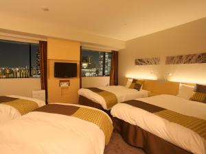 Postel nebo postele na pokoji v ubytování Hotel Keihan Kyobashi Grande