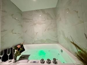 a bathroom with a bath tub with a sink at La Bulle Roanne centre-ville - Jaccuzi & Clim in Roanne +24 photos