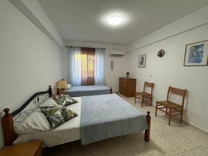 a bedroom with a bed and two chairs in it at Seaview apartment with garden & pool in Paphos City +21 photos