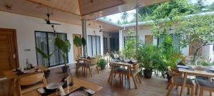a restaurant with tables and chairs and plants at Infinity Beach Dhigurah in Dhigurah
