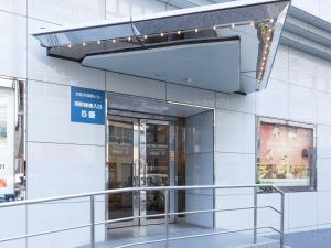 a glass entrance to a building with a sign on it at Hotel Keihan Kyobashi Grande in Osaka