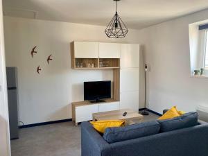 a living room with a blue couch and a tv at L'écrin du général in Armentières +10 photos