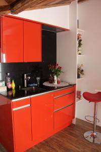 uma cozinha com armários vermelhos e um lavatório em Haus Rosa em Zermatt