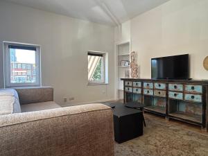 a living room with a couch and a flat screen tv at Appartement Seepaardje in Scheveningen