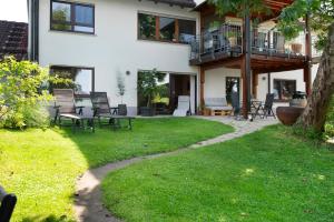 une maison avec une cour avec des chaises et un balcon dans l'établissement Fewo Fuchs, à Salem