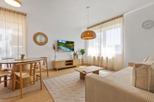 un soggiorno con un divano e un tavolo di Boho Apt w Jacuzzi, Grill & Garden a Modra