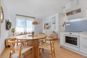 una cucina e una sala da pranzo con tavolo e sedie di Boho Apt w Jacuzzi, Grill & Garden a Modra