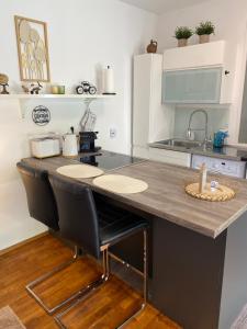 uma cozinha com um balcão com cadeiras e um lavatório em Studio im Wienerwald - Mödling em Mödling