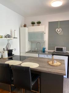 uma cozinha com uma ilha de cozinha com cadeiras e um balcão em Studio im Wienerwald - Mödling em Mödling