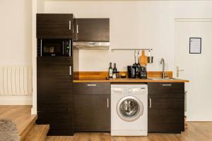 a kitchen with a washing machine in a kitchen at Suite Les Nébuleuses, Terreaux Capucins in Lyon