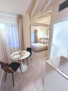 Una sala de estar con una mesa y sillas y una cama. en Lemon Suites Santander, en Santander