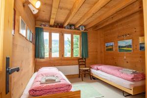 a bedroom with two beds in a log cabin at Chalet Meiseli in Adelboden