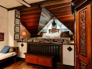 a bedroom with a bed in a room with wooden ceilings at Svarna Heritage in Kalyānpur