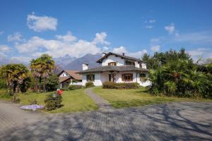 a white house with a driveway in front of it at Appartamento Vela in Colico