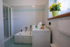 a white bathroom with a tub and a sink at Appartamento Vela in Colico +12 photos
