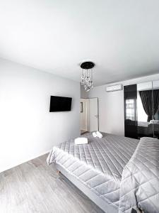a white bedroom with a large bed and a chandelier at Luxuriöse Wohnung in Herzens von Sanremo in Sanremo