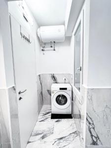 a white bathroom with a washing machine in it at Luxuriöse Wohnung in Herzens von Sanremo in Sanremo