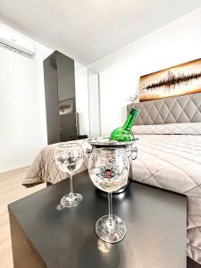 two wine glasses sitting on a table in front of a bed at Luxuriöse Wohnung in Herzens von Sanremo in Sanremo +7 photos