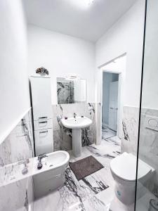 a white bathroom with a sink and a toilet at Luxuriöse Wohnung in Herzens von Sanremo in Sanremo