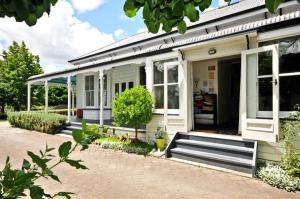 uma casa com um alpendre e um banco em frente em Villa Shakespeare em Cambridge