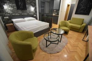 a bedroom with a bed and two chairs and a table at Station 44 Apartments in Bitola +8 photos