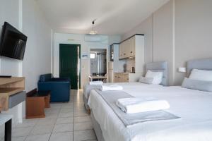 una camera d'albergo con due letti e una cucina di Sunset Triple 1 a Ayios Nikitas Altre 18 foto
