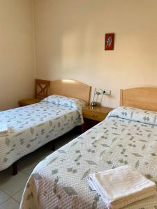 a bedroom with two beds and a table with a lamp at Residencia Sagrada Familia in La Seu d'Urgell +16 photos