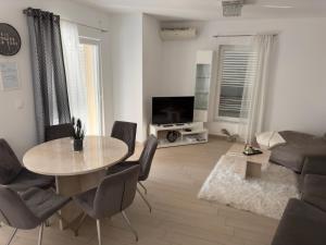 a living room with a table and a couch at Apartment Josip 2 in Tribunj