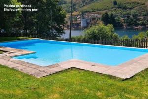 a swimming pool in the grass next to a river at Casinha de Padrões in Venda Nova
