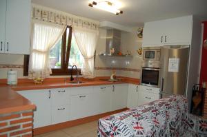 a kitchen with white cabinets and a counter top at Casa el patio in Ampuero