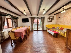 a living room with a couch and a table and chairs at Cabana Zimbru mica in Băile Borşa