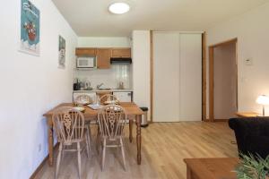 a kitchen and dining room with a wooden table and chairs at Appt Le Grand Tetras F14 - 4 pers in Samoëns