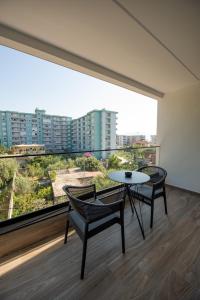 a room with a table and chairs and a large window at Calma Boutique Hotel in Vlorë