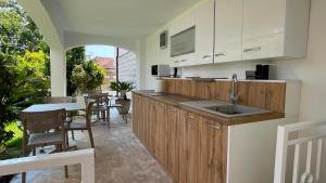 a kitchen with a sink and a table with chairs at Ancora Hotel in Herceg-Novi
