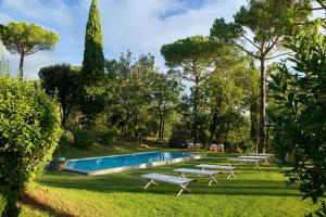 a pool with chaise lounge chairs in the grass at Villa Chiesetti in Mosciano