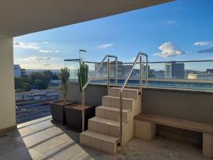 a balcony with stairs and a view of a city at Chic City Flat - Sky High with a View in Windhoek