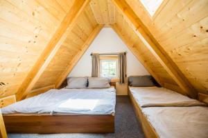two beds in the attic of a log cabin at Wellness Roubenka Goldenstein in Branná