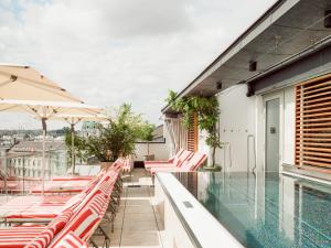 a balcony with chairs and a swimming pool at Grand Ferdinand Vienna – Your Hotel In The City Center in Vienna