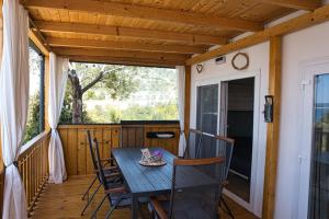 a porch with a wooden table and chairs on it at Mobilehome Palema 16 in Drage