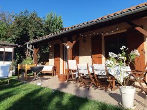 a patio with chairs and a table in a yard at KERJEANNE in Cailloux-sur-Fontaines