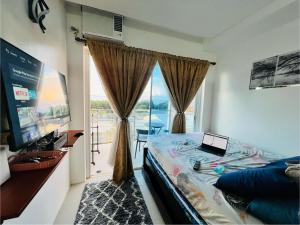 a bedroom with a bed and a window with a laptop on it at Condo at Primavera city next to SM Mall in Cagayan de Oro