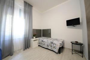 um quarto com uma cama e uma televisão em AFFITTACAMERE A CASA MIA em Roma