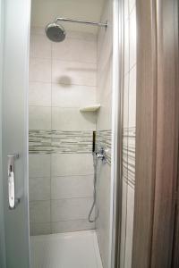 um banheiro com chuveiro com porta de vidro em AFFITTACAMERE A CASA MIA em Roma
